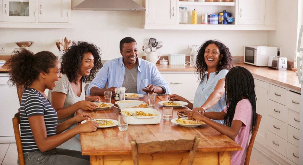 Family of five laughing around the dinner table