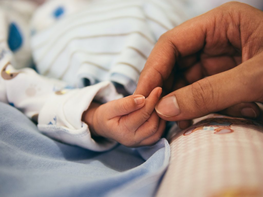 Person holding baby's hand