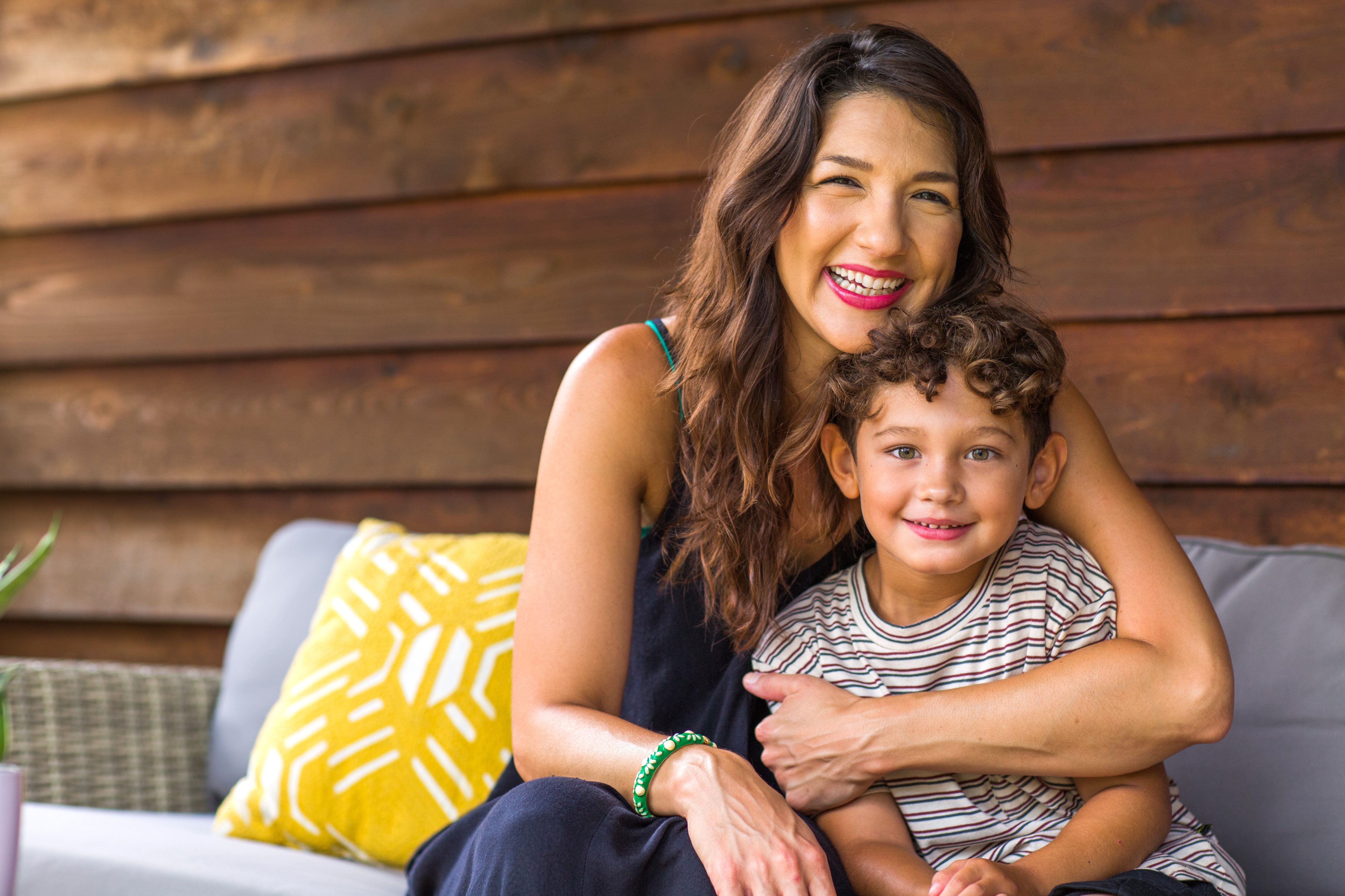 Hispanic mother sitting and hugging her son.