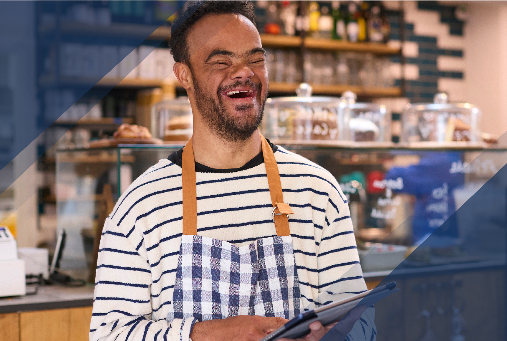 Smiling Man With Down Syndrome Working In Food Shop Using Digital Tablet