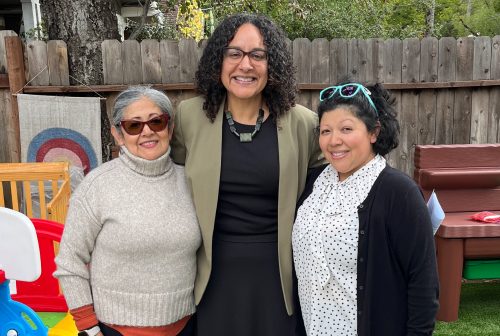 Secretary Kim Johnson, Esperanza and Scarlett standing in the yard of their family child care home